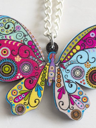 Kleurige vlinder hanger aan witte ketting